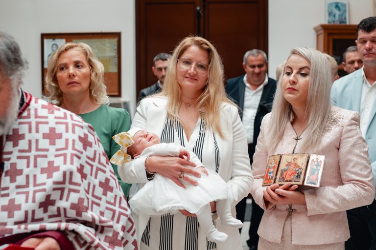 Nasele țin pe Olivia adormită în fața porții bisericii