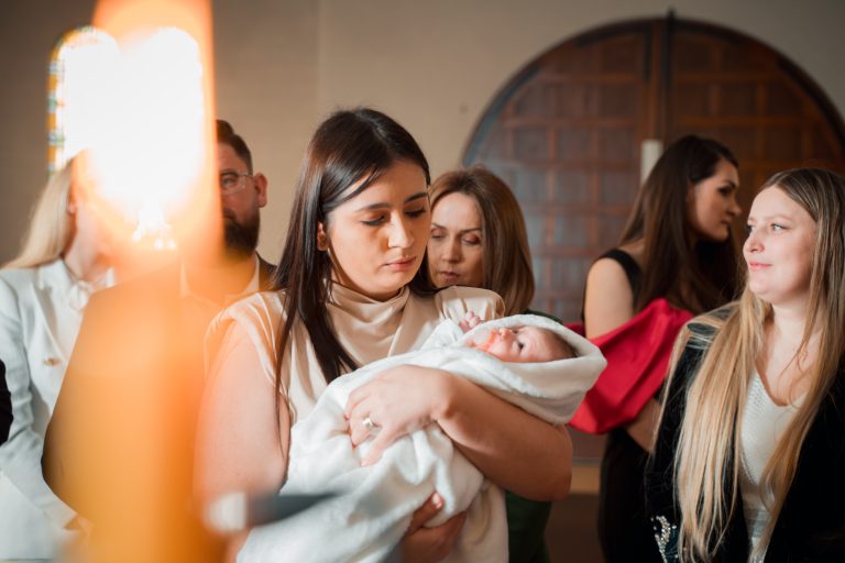 Nașa o ține pe micuța Aria în brațe, la botezul din Paris