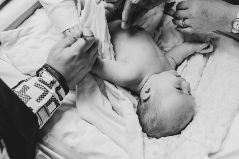 Fotografie alb-negru cu nasele schimbând-o pe Olivia înainte de botez