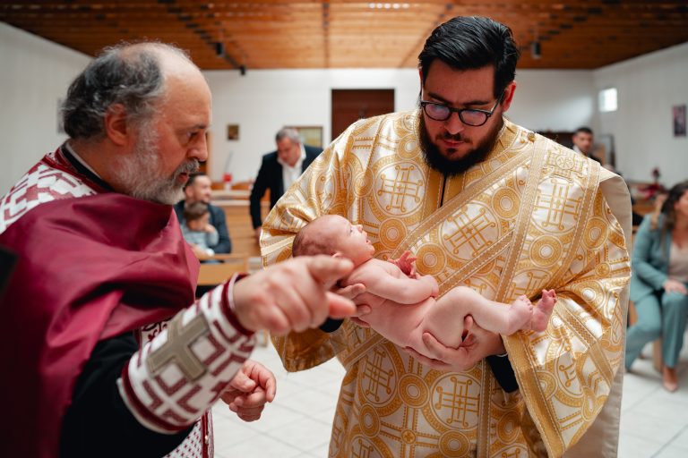 Olivia ținută în brațe de ajutorul preotului, în biserică