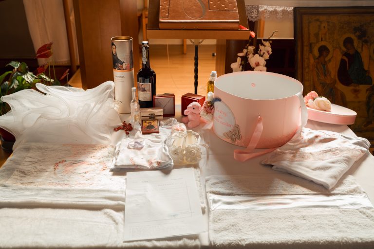 Trusoul și lumânările Ariei așezate pe masa din biserică, botez Paris