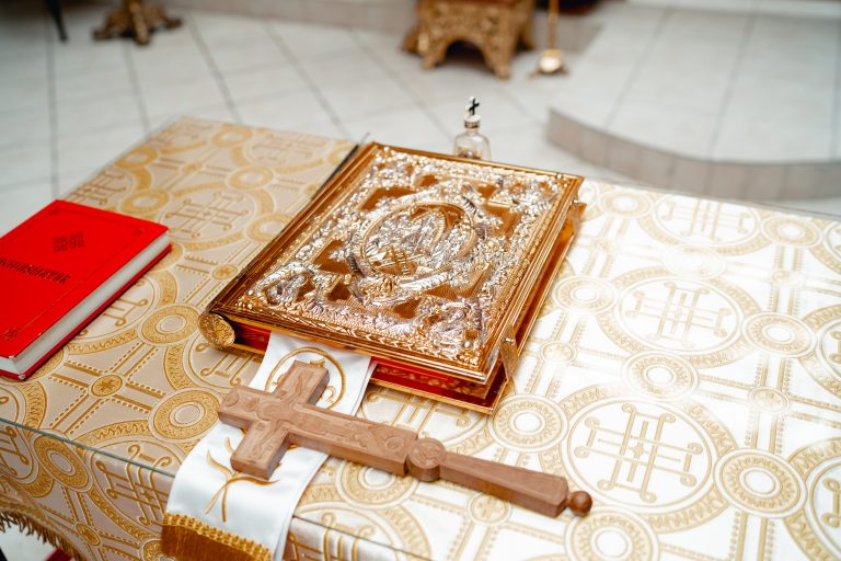 Sfânta Evanghelie și crucea de lemn așezate pe altar în timpul botezului Oliviei, detaliu simbolic surprins de Alexandru Gaspar.